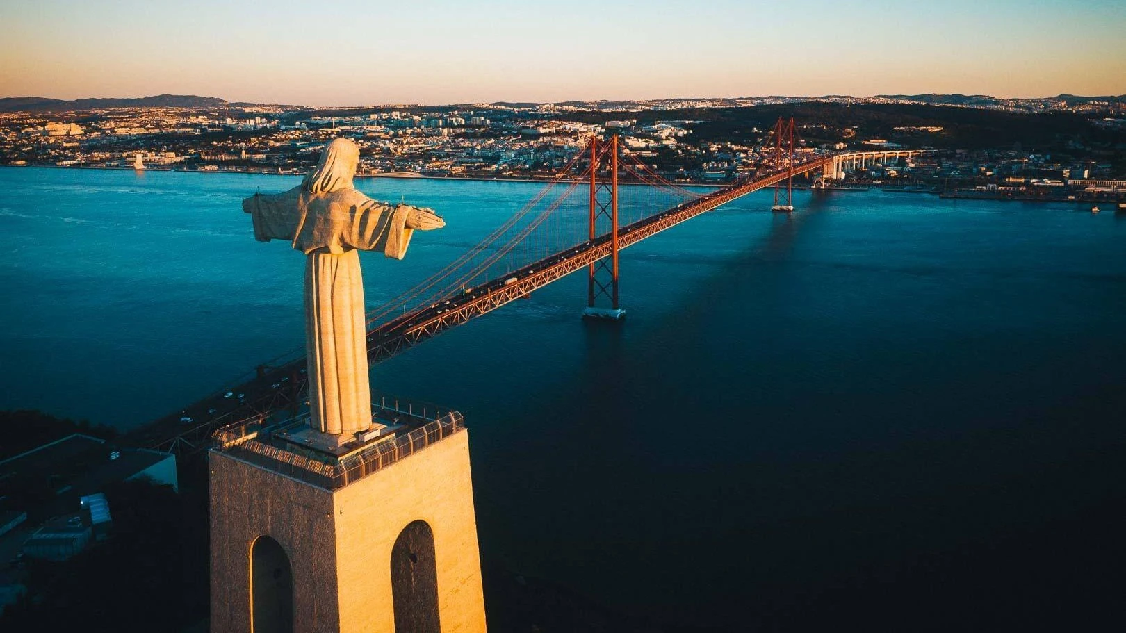 View of the 25 de Abril Bridge and Cristo Rei across the Tagus river near Lisbon